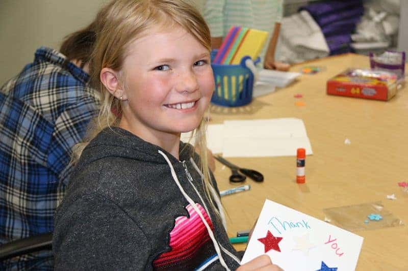 5th grader at a desk smiles for the camera