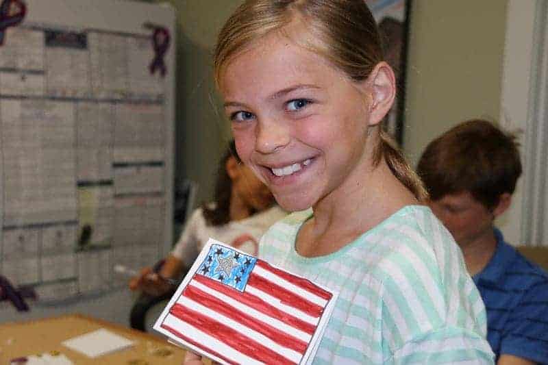 5th grader holding a drawing of the american flag