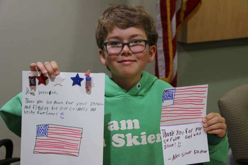 5th grader holding a letter to the veterans