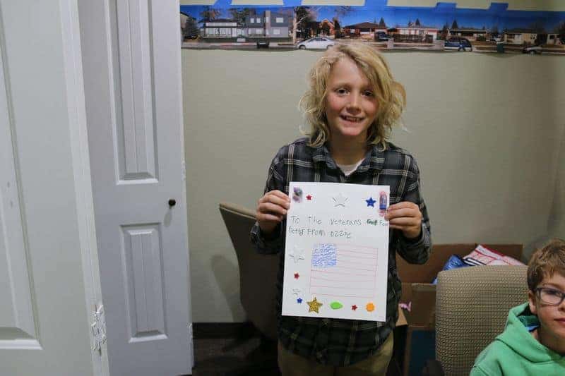 5th grader holding a letter to the veterans