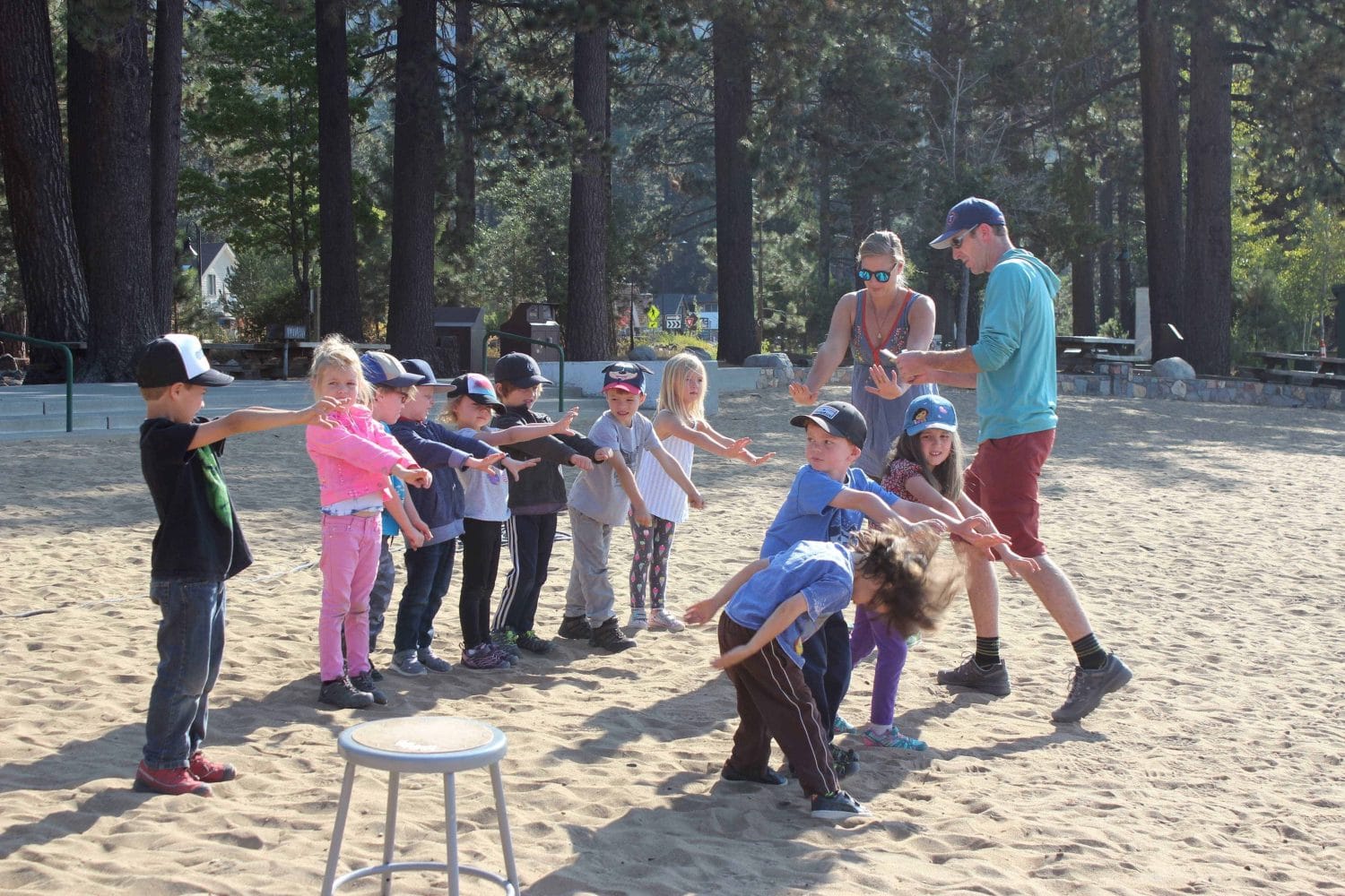 students with their teacher in the sand