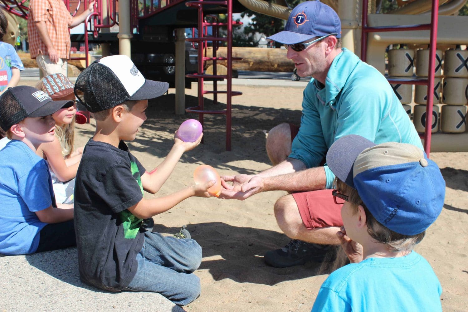 student and teacher holding water balloons