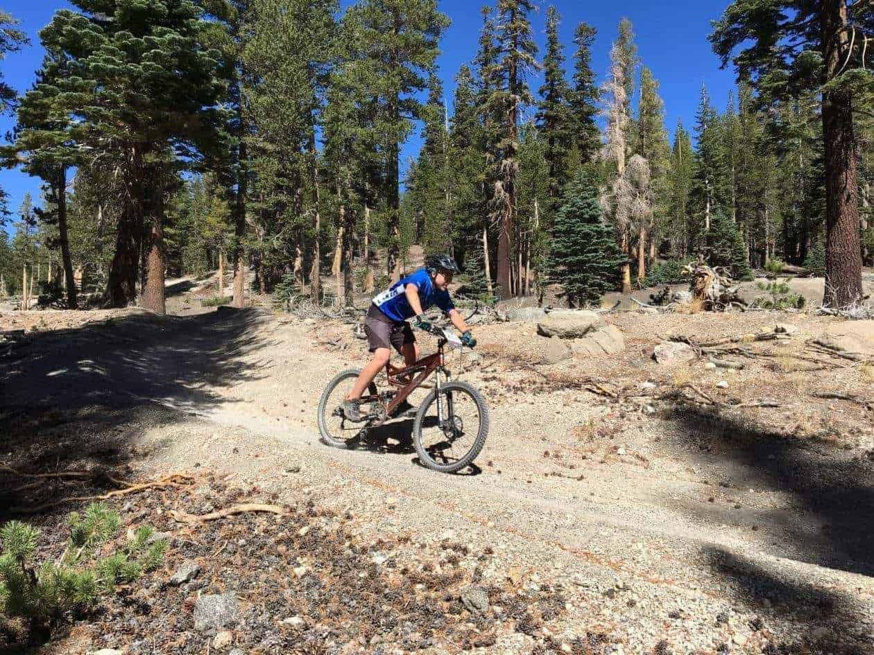 student mountain biking down a trail