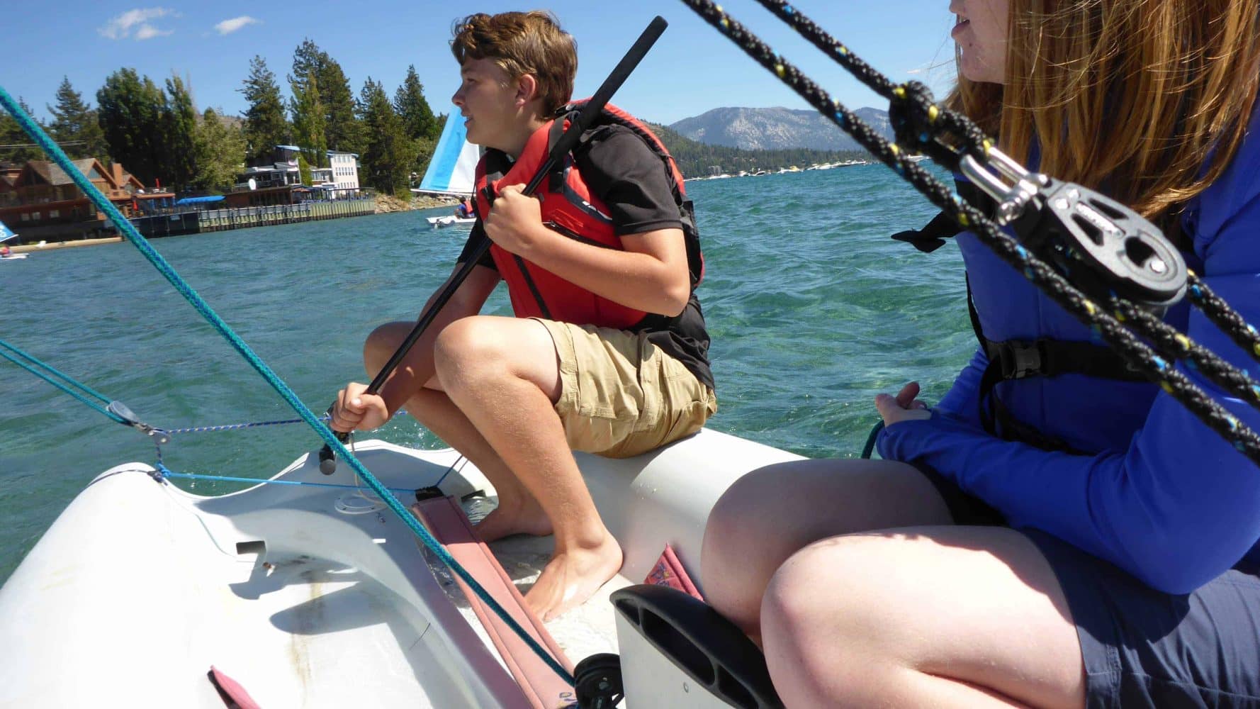 students in the ocean on small sailboats