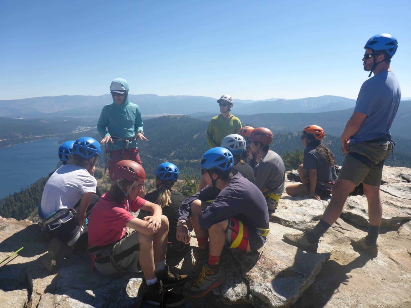 rock climbing team sitting on a cliff