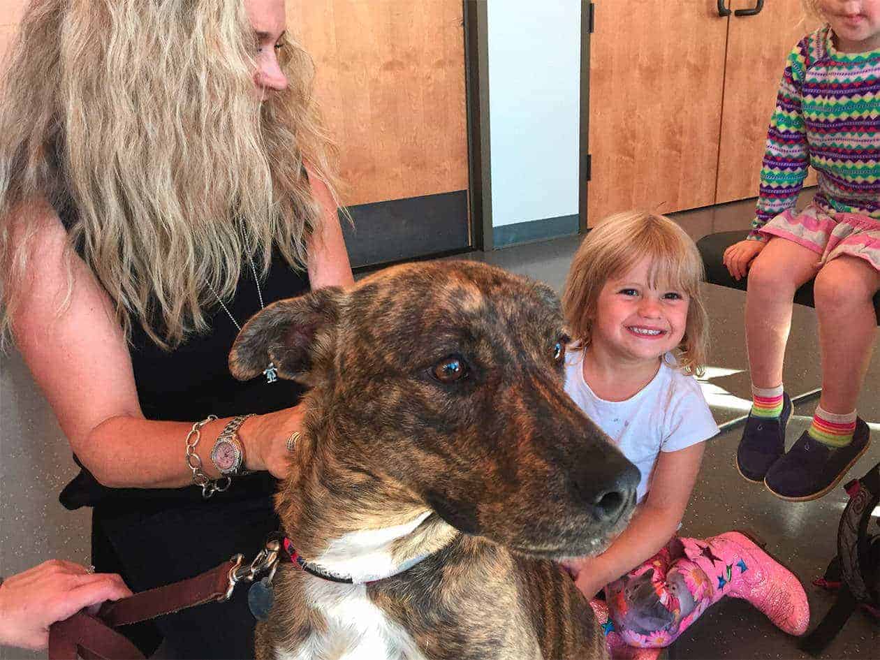 student and teacher petting a dog