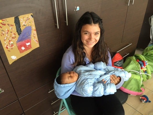 sitting student holding a sleeping baby