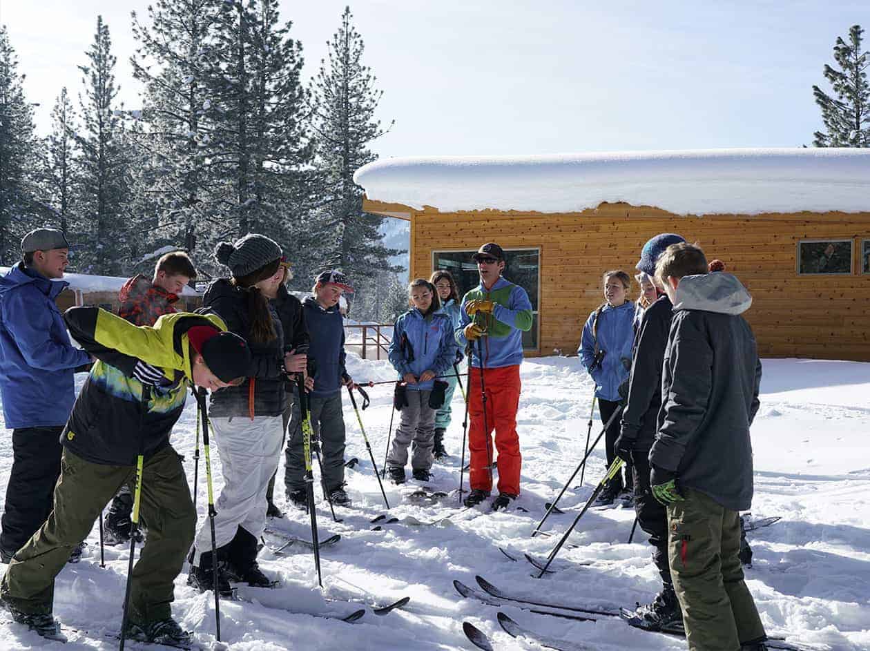 students on their skis standing in the snow