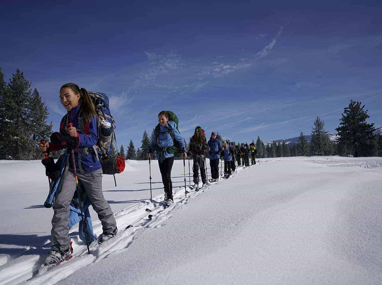 students trekking through the snow