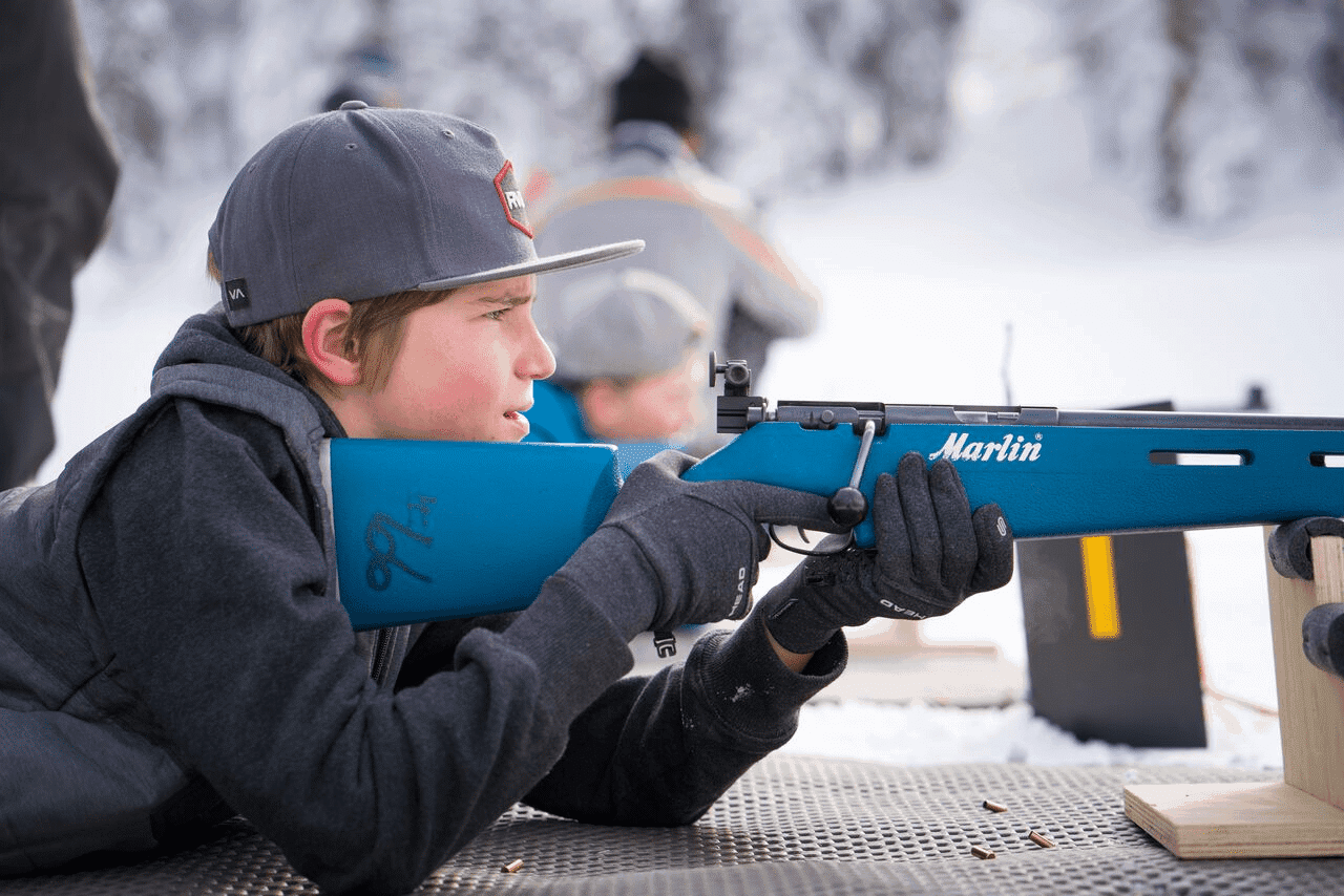 student biathlete aiming his rifle