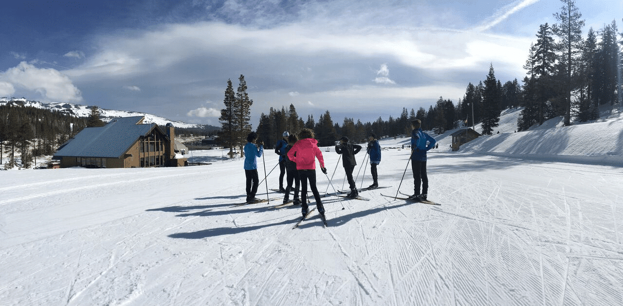 students with skis standing in the snow