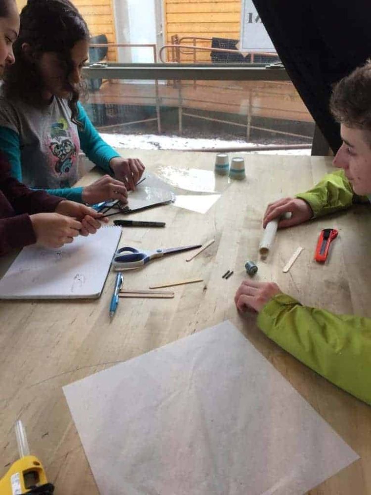 students sitting at a desk working on turbine prototypes