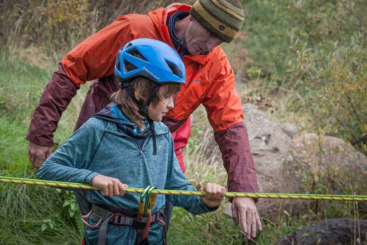 student hiking with a rope as a guide