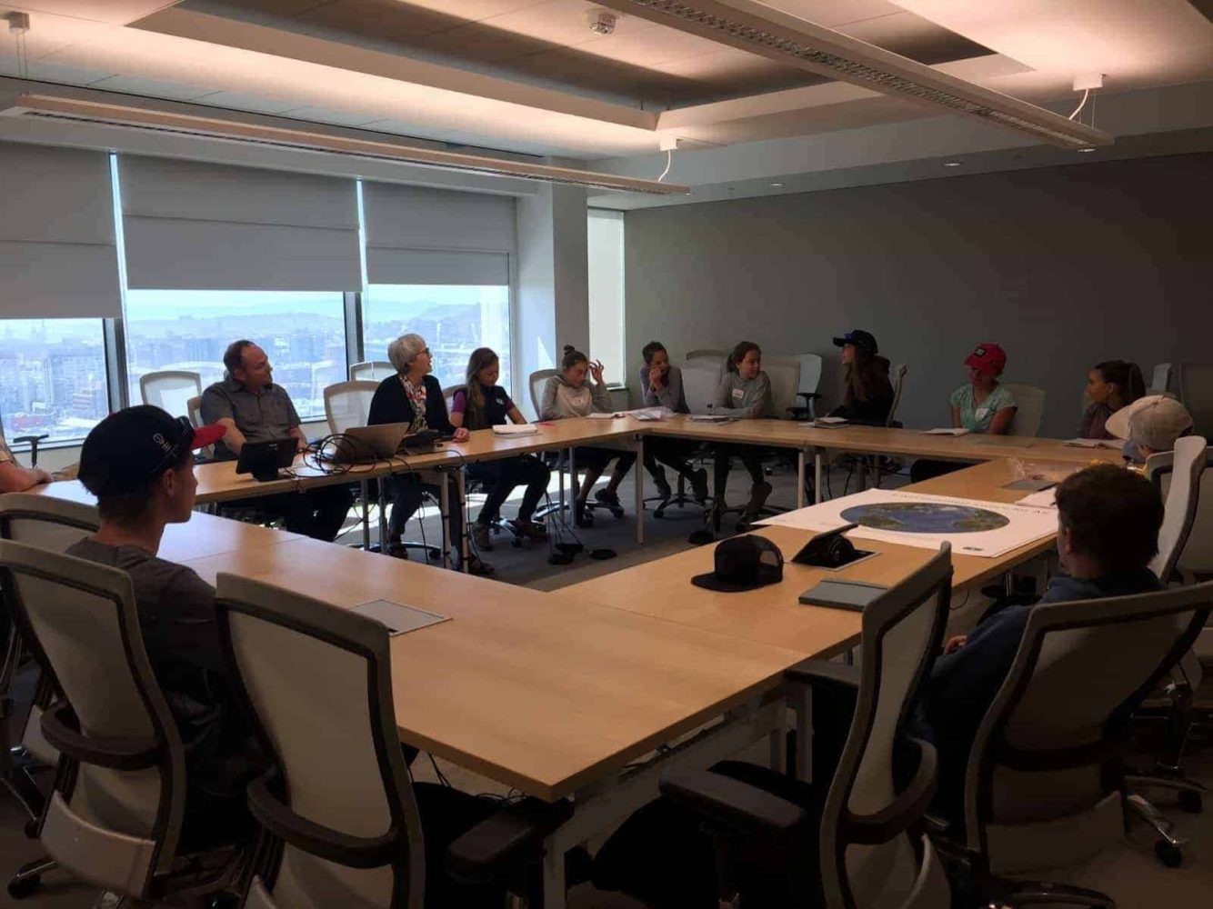 7th graders at a desk talking to environmental justice experts