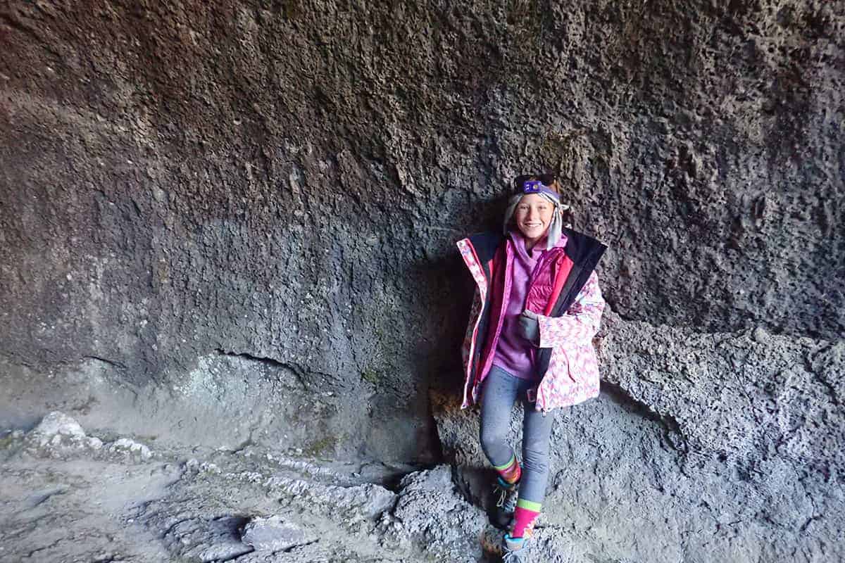 student in a cave smiles for the camera