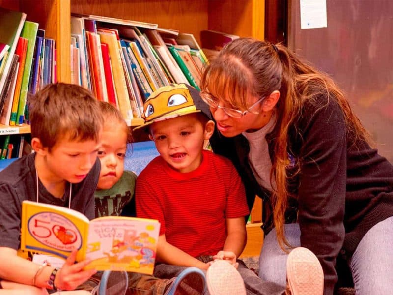 teacher reading a book with her students