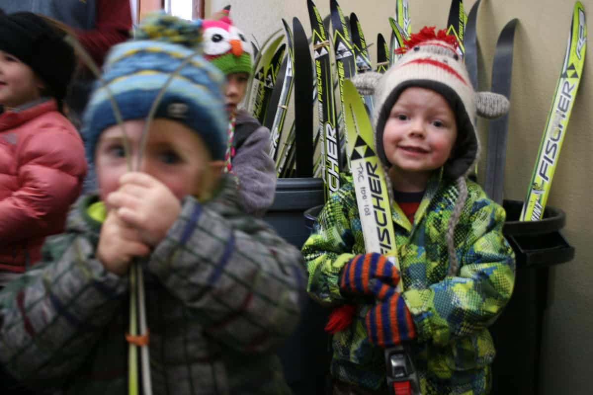 pre-k students getting skis from a bin