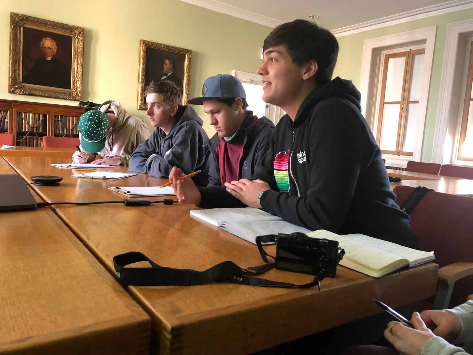 students at a desk conducting an interview