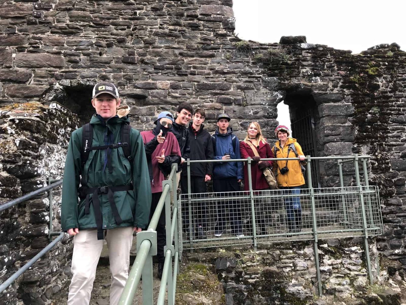 students on steps smile for the camera