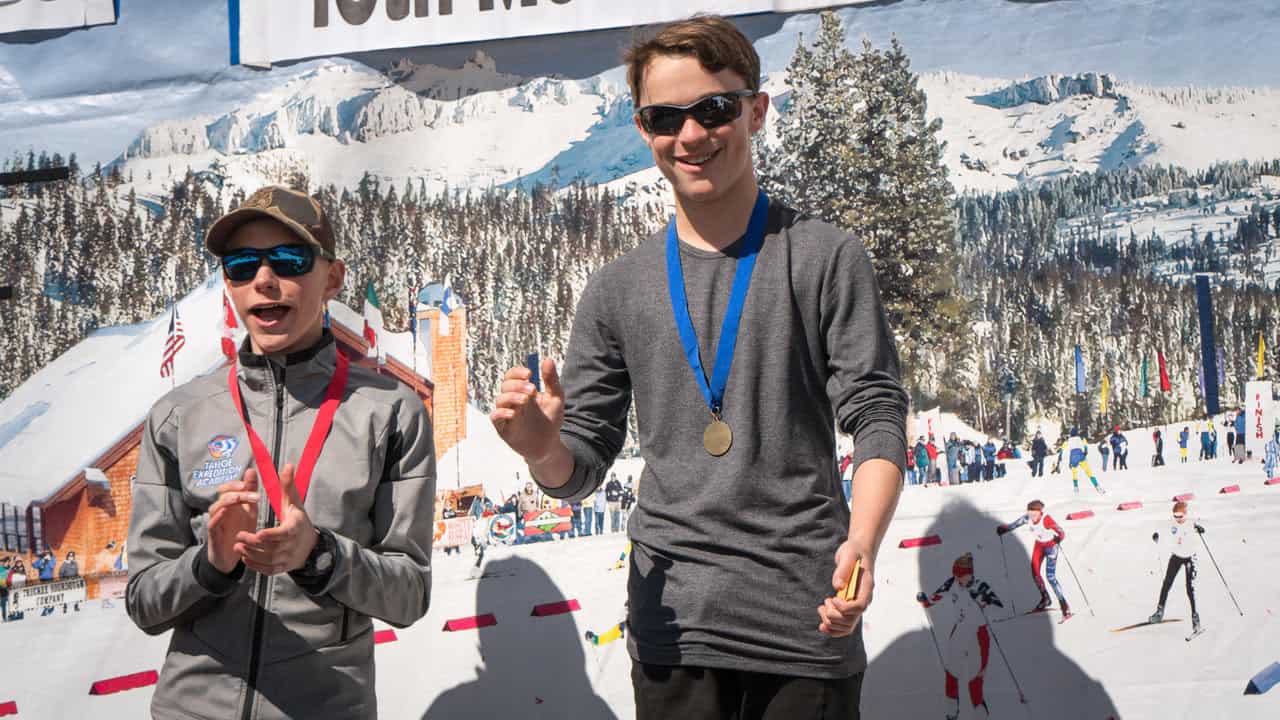 biathletes with medals atop the podium