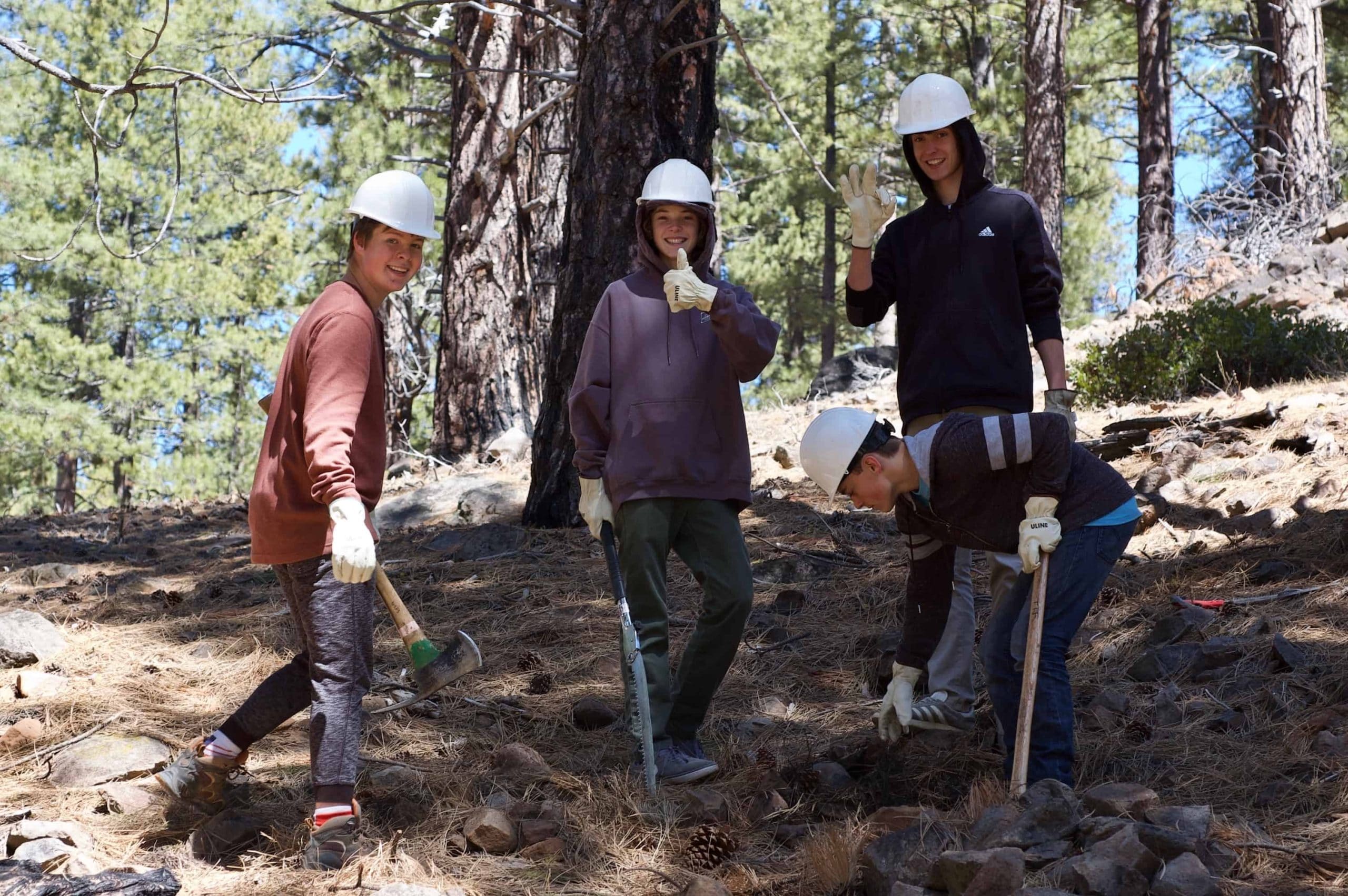 students with hard hats in a forest