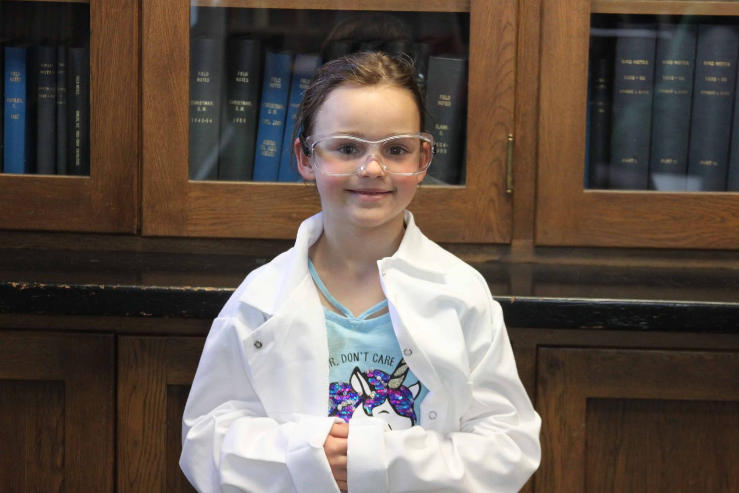 kindergartener with lab coat smiling