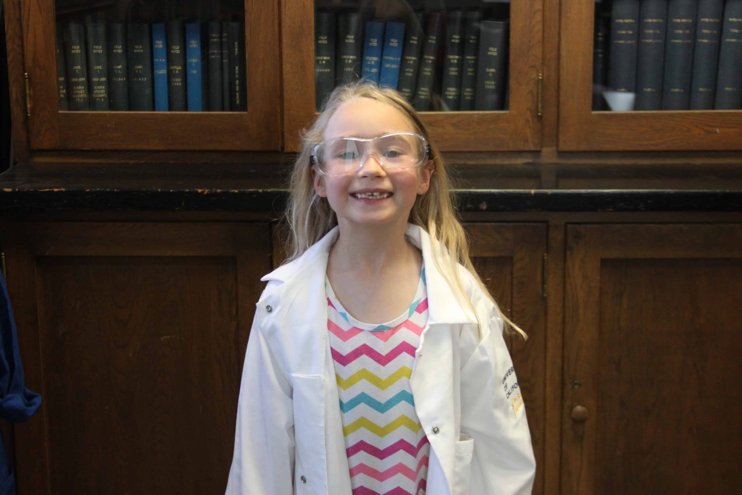 kindergartener with lab coat smiling