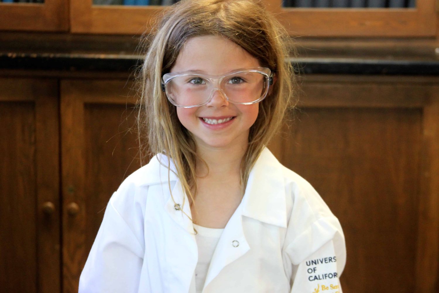 kindergartener with lab coat smiling