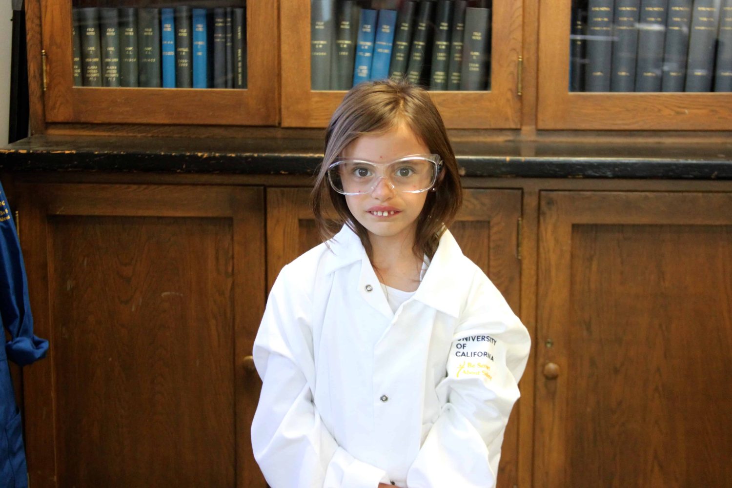 kindergartener with lab coat smiling