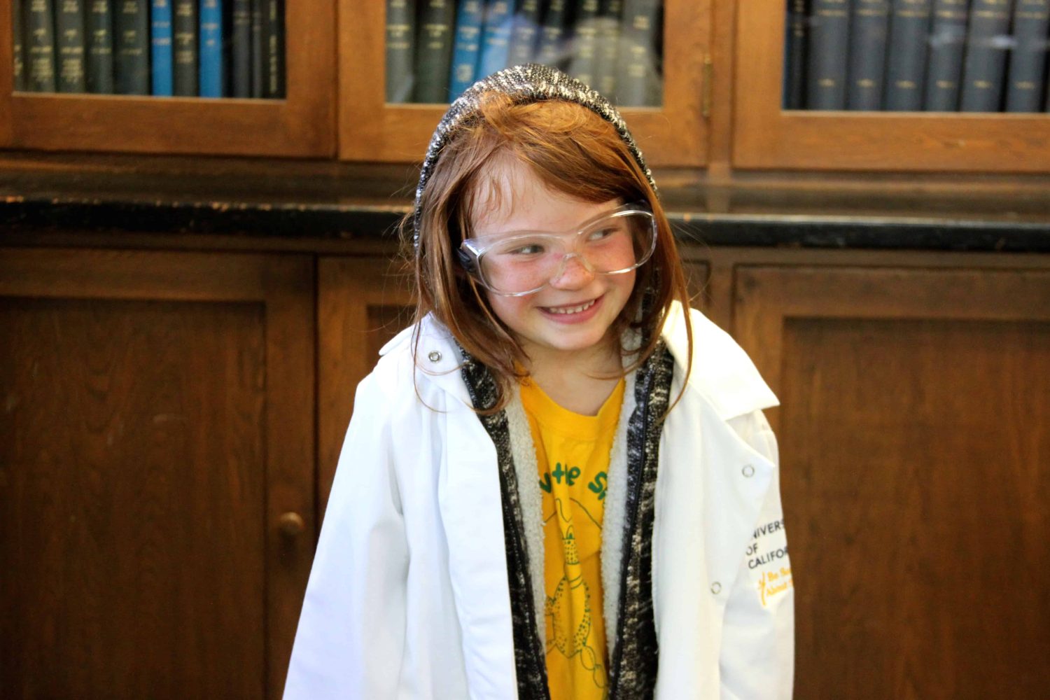 kindergartener with lab coat smiling