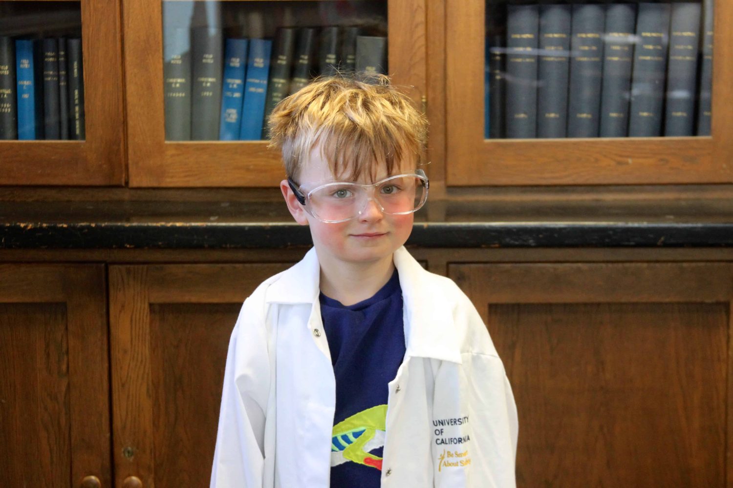 kindergartener with lab coat smiling