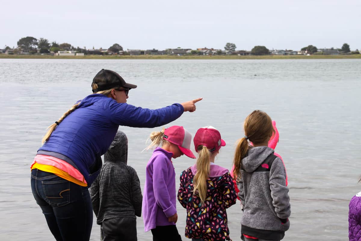 teacher showing students the ocean