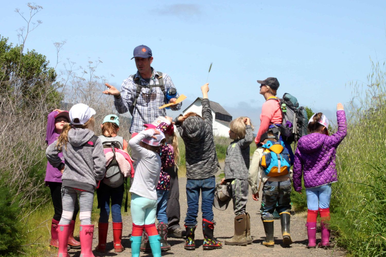 students following their teacher down a dirt road