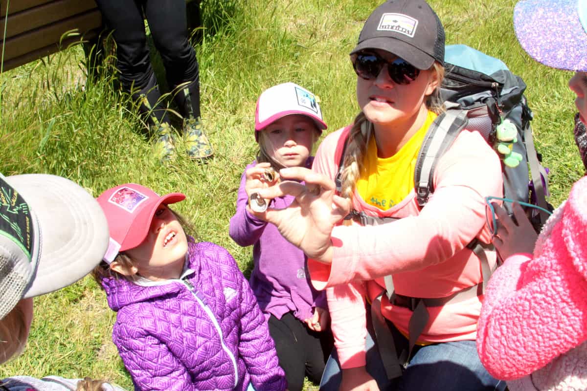 kindergarteners with their teacher in a field