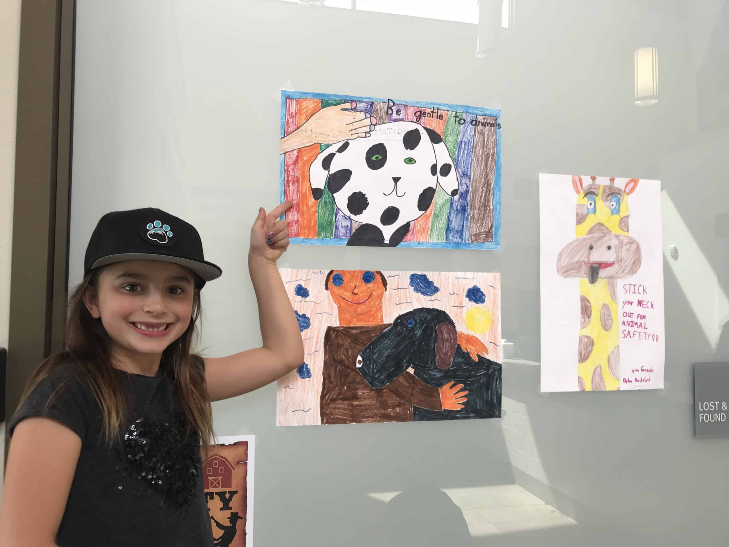 student pointing to art on a wall