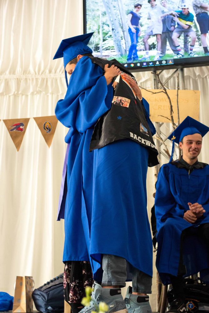 graduates hugging onstage