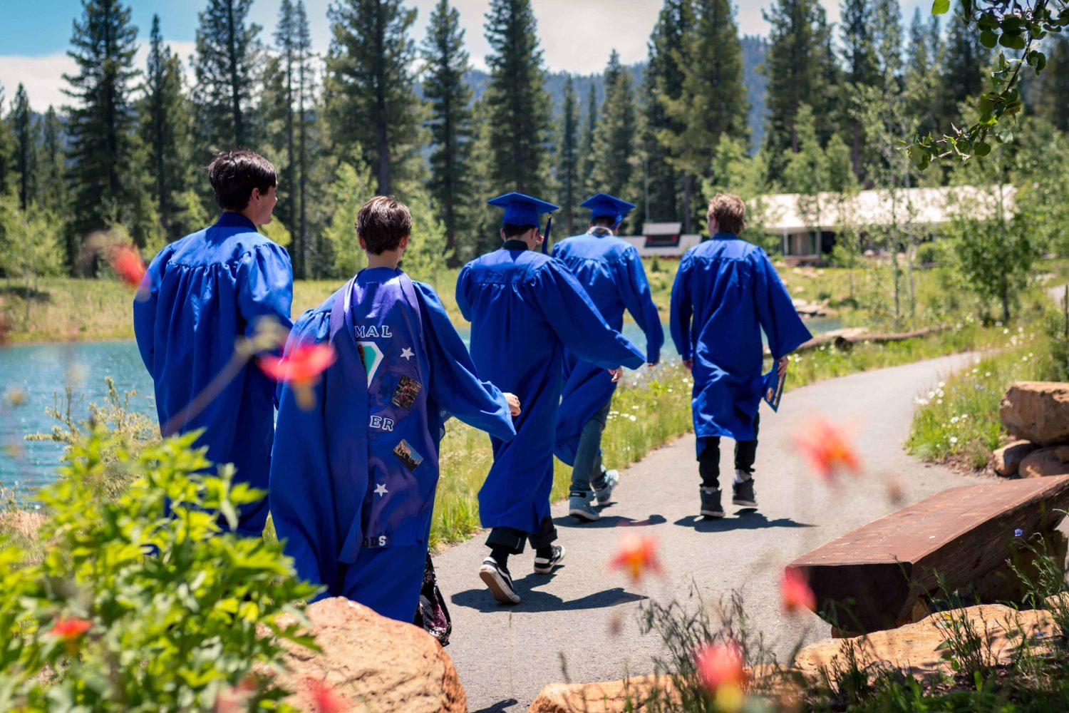 graduates walking down a trail