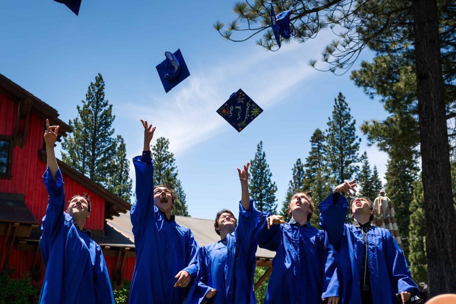 A group of students from the graduating class, throwing their caps in the air