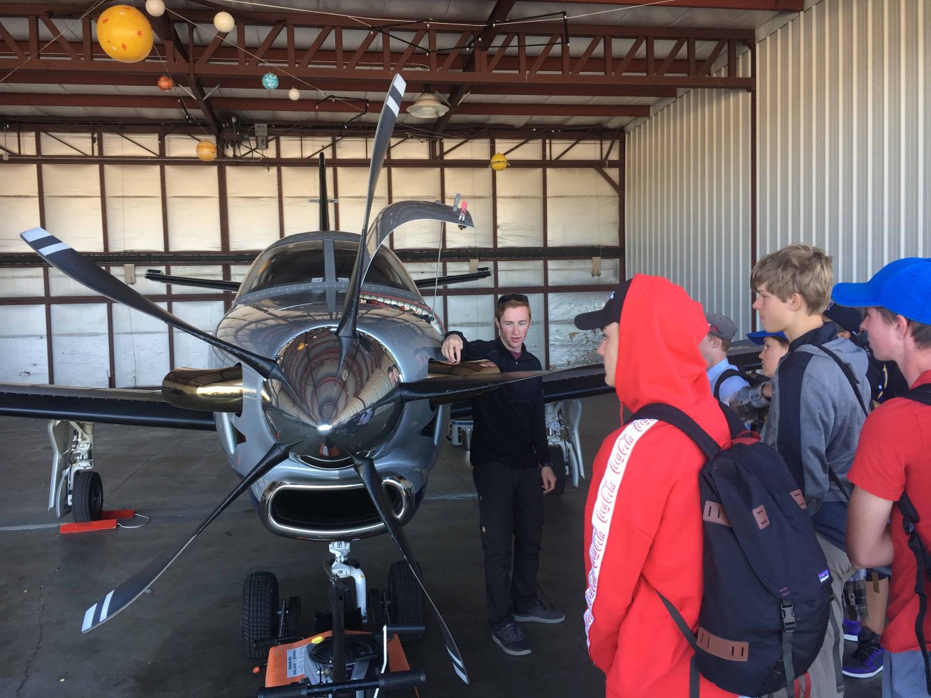 commercial pilot speaking with students next to a plane