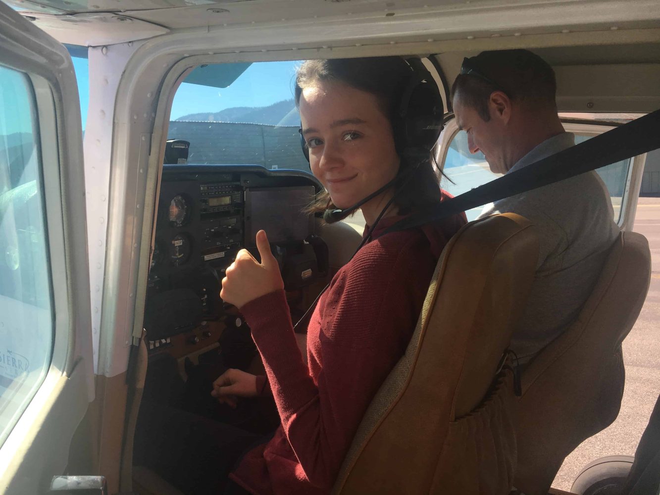 student in a plane cockpit with an instructor