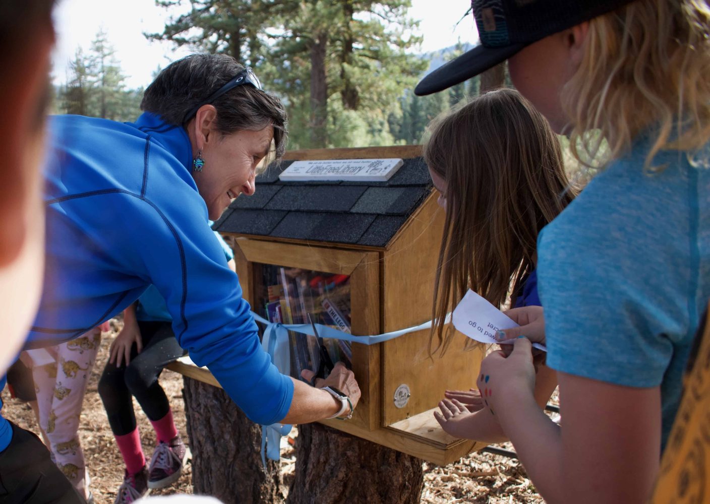 students putting books into the little library