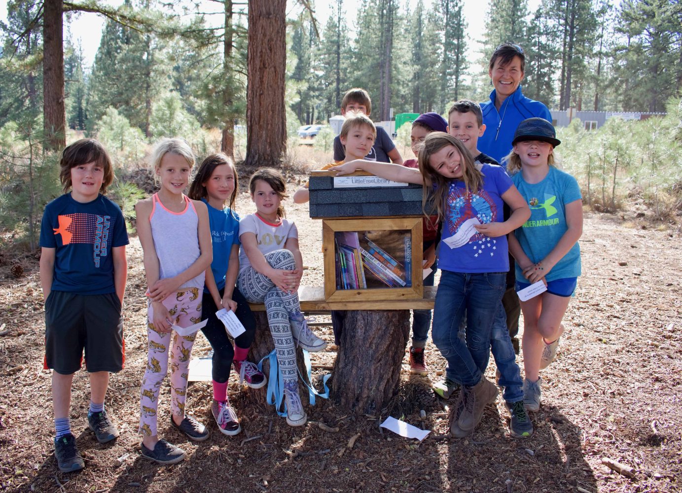 students standing next to the finished little library