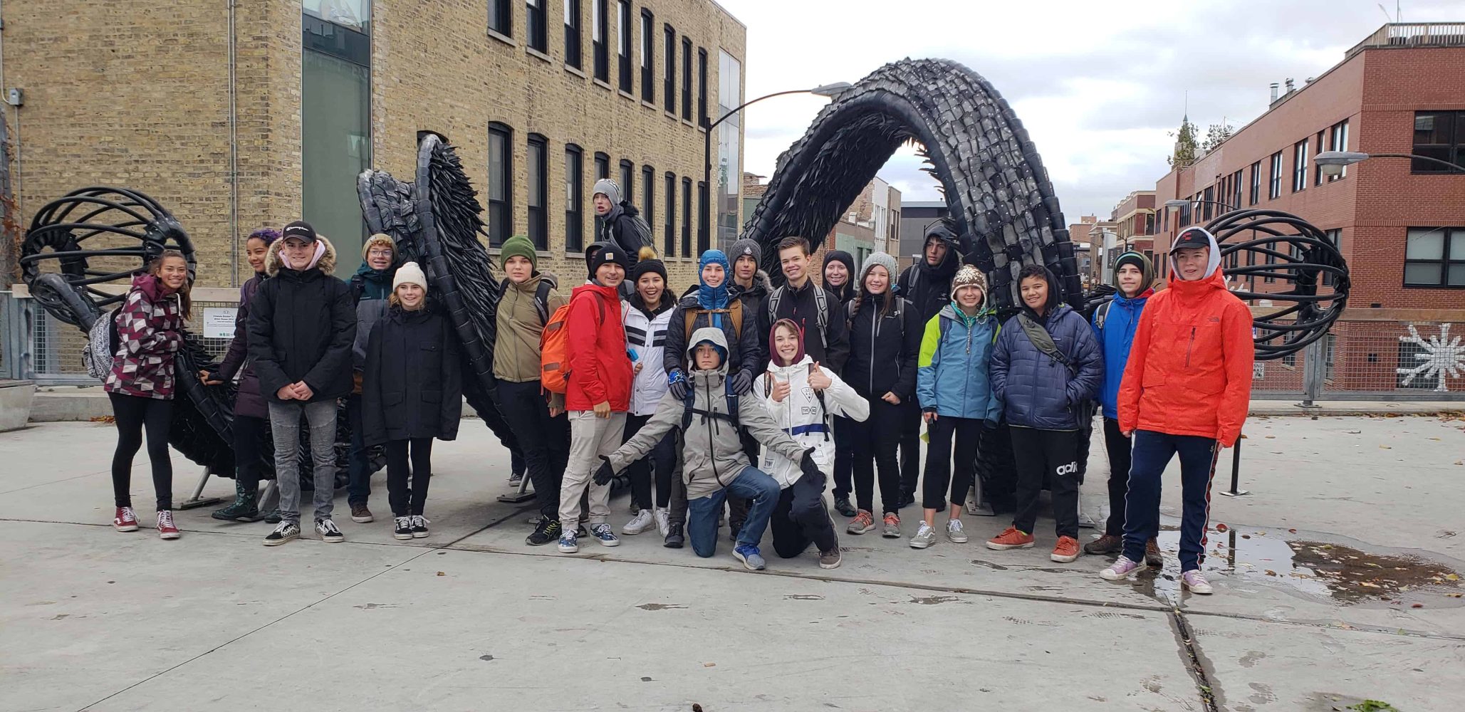 the high school class in front of a sculpture
