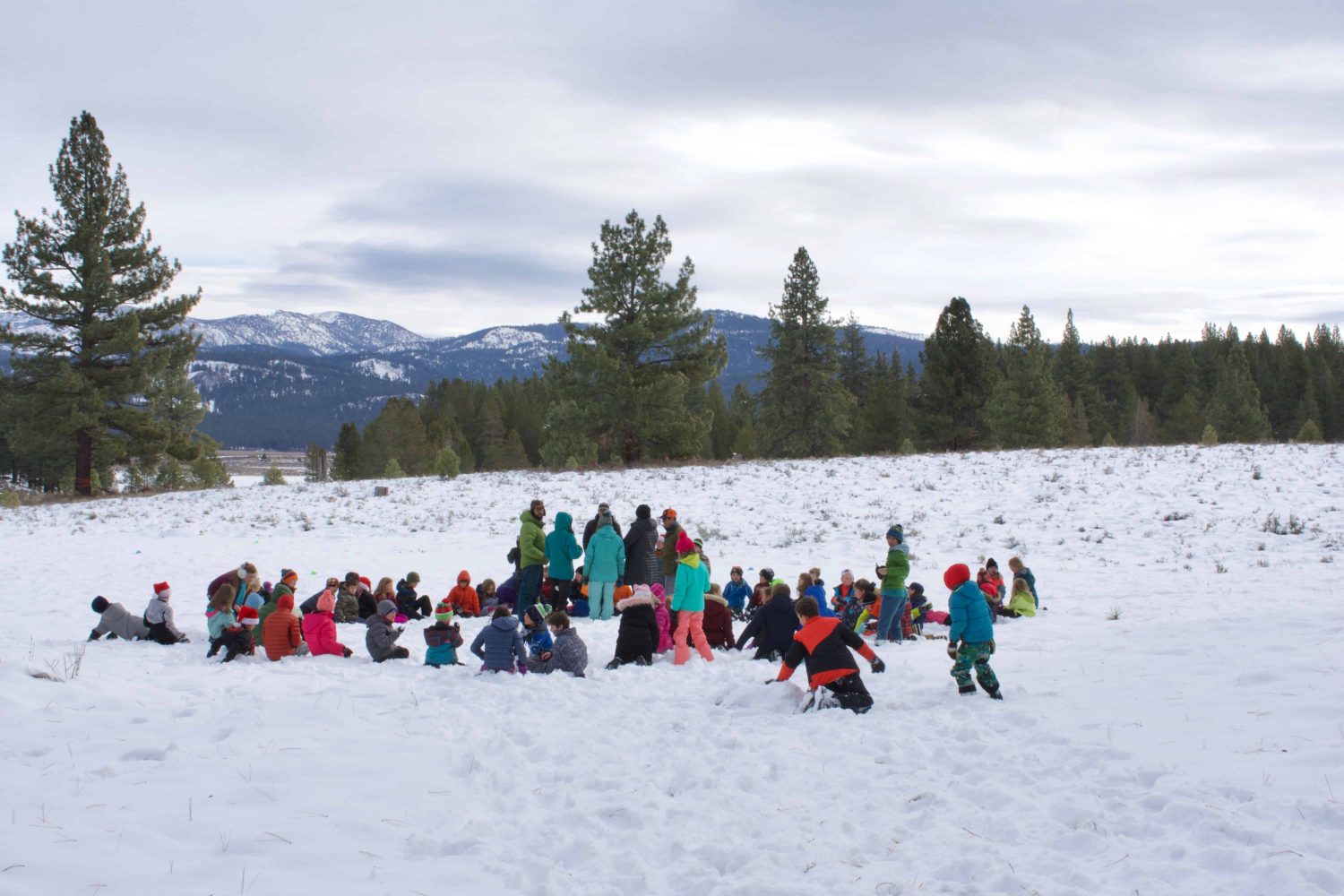 elementary students sitting in a circle in the snow