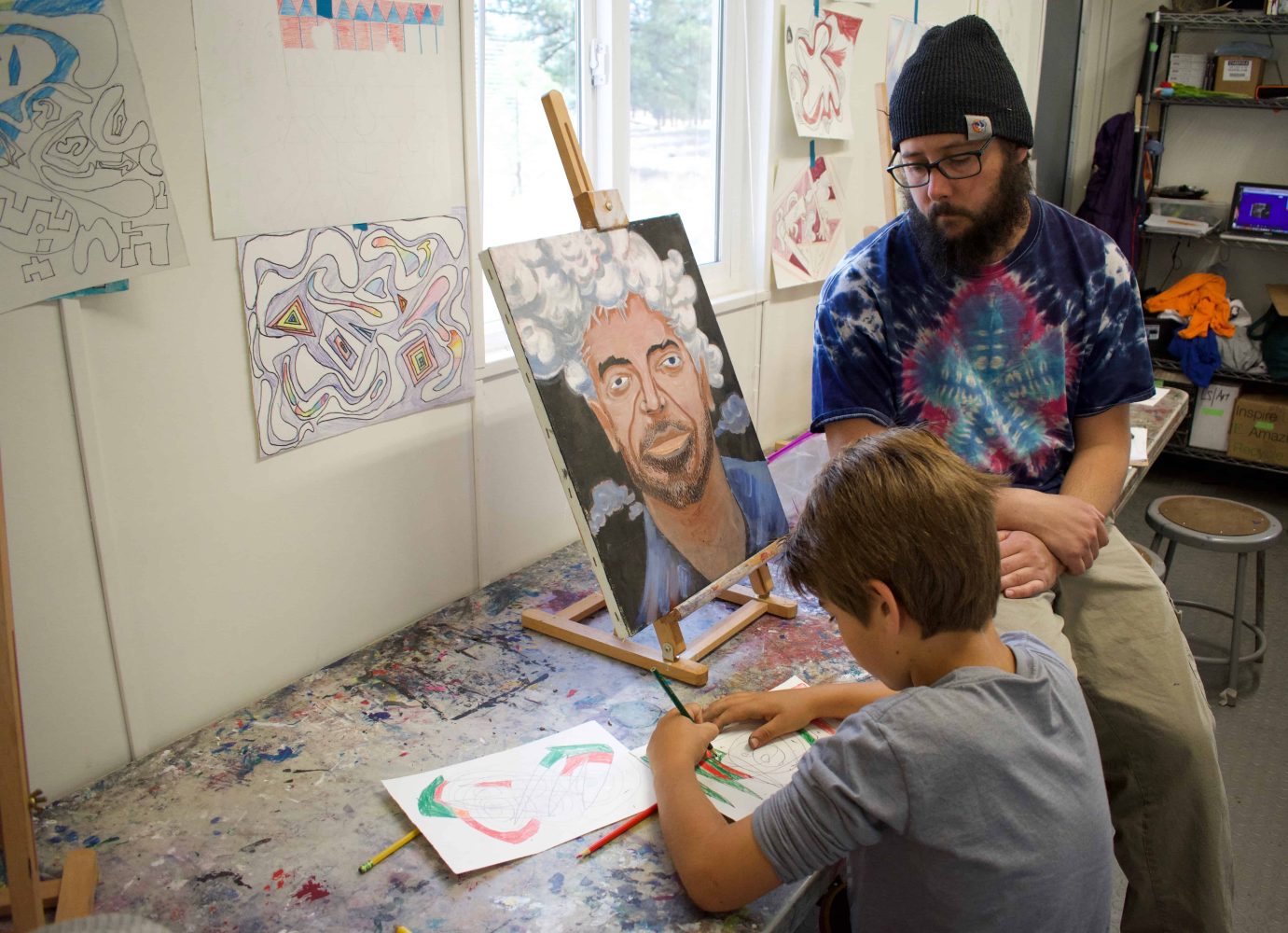 teacher watches a student color