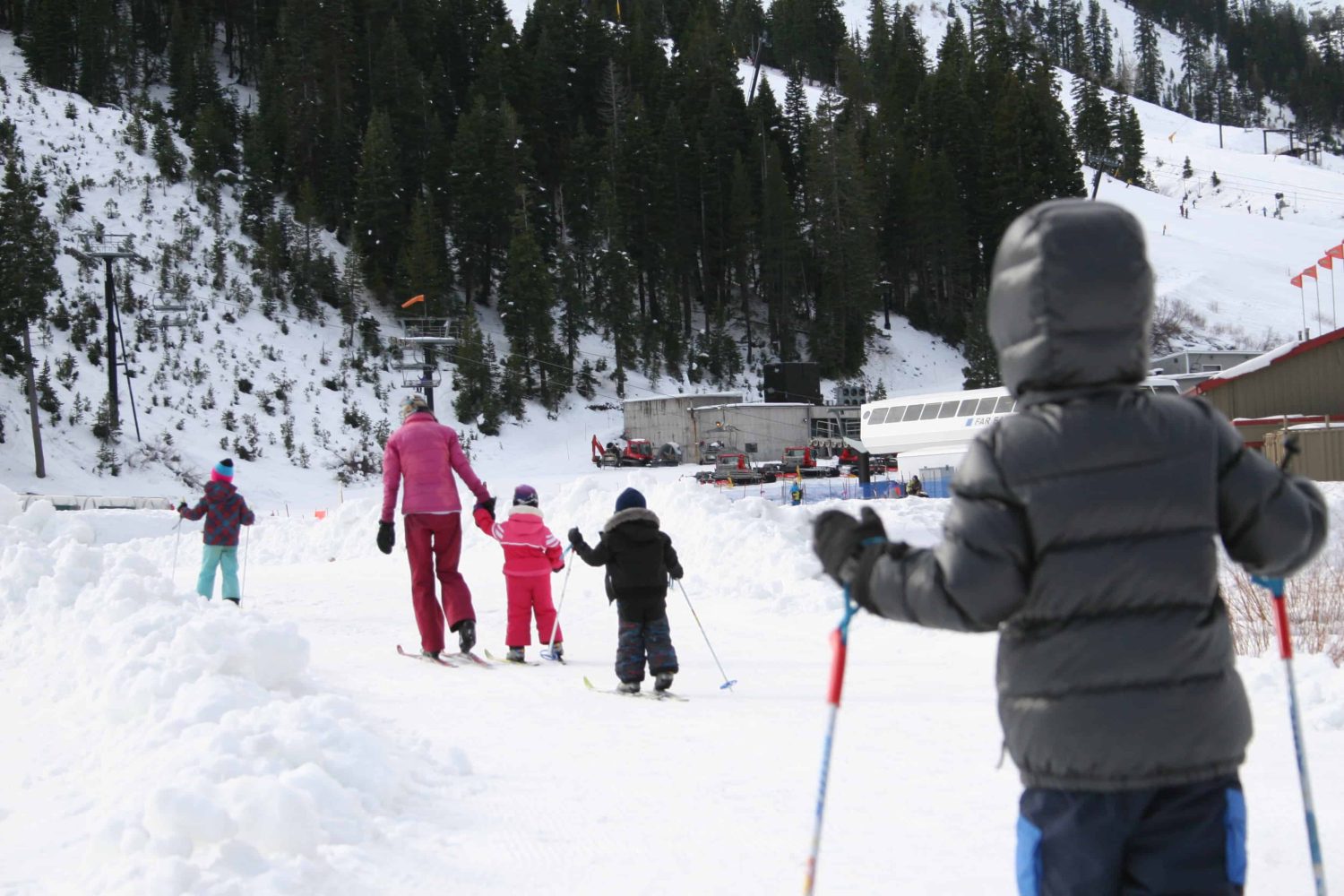 pre-k students on skis closely following their teacher