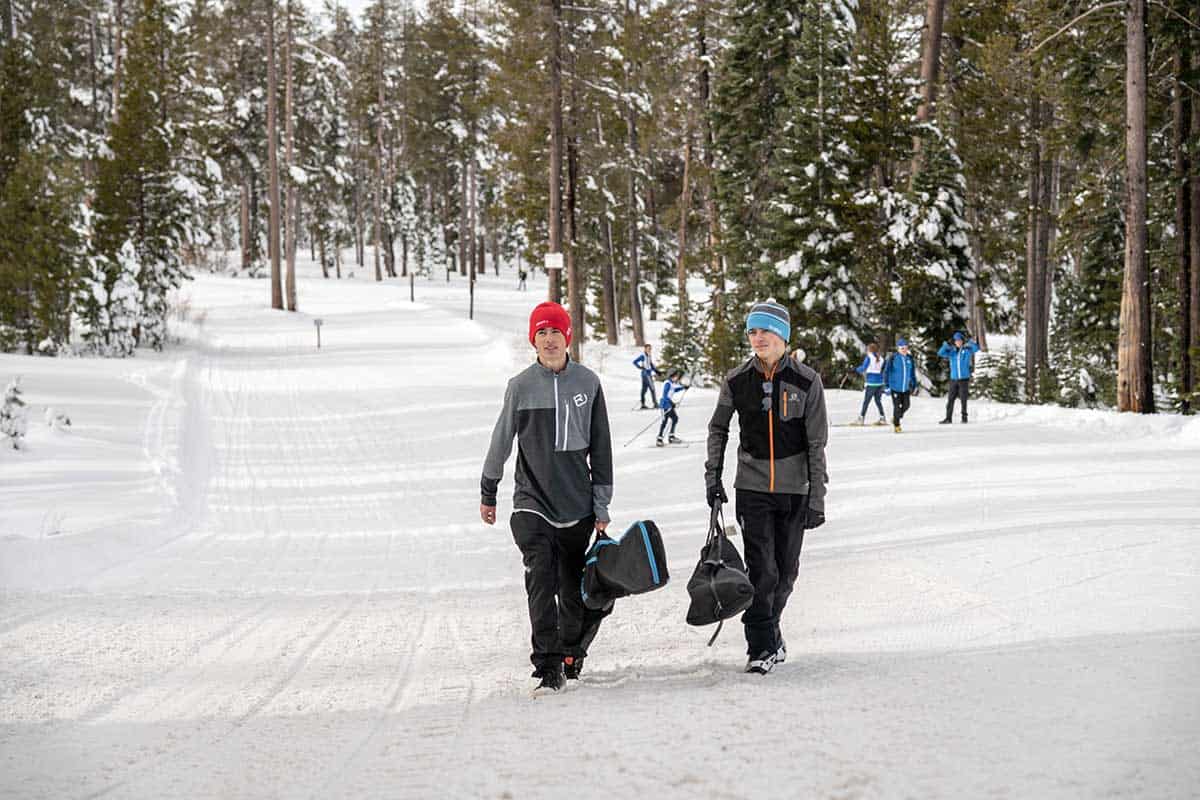 biathlete students walking up a snowy trail