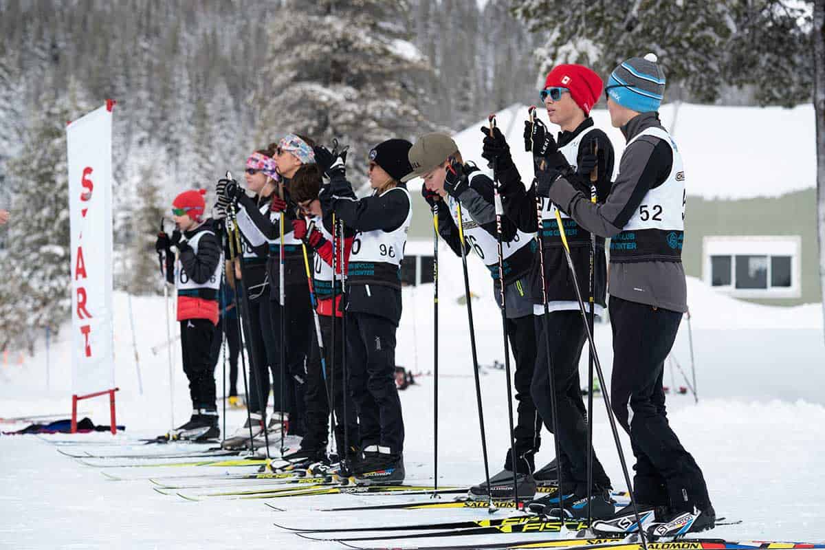 biathlete students on skis at the starting line