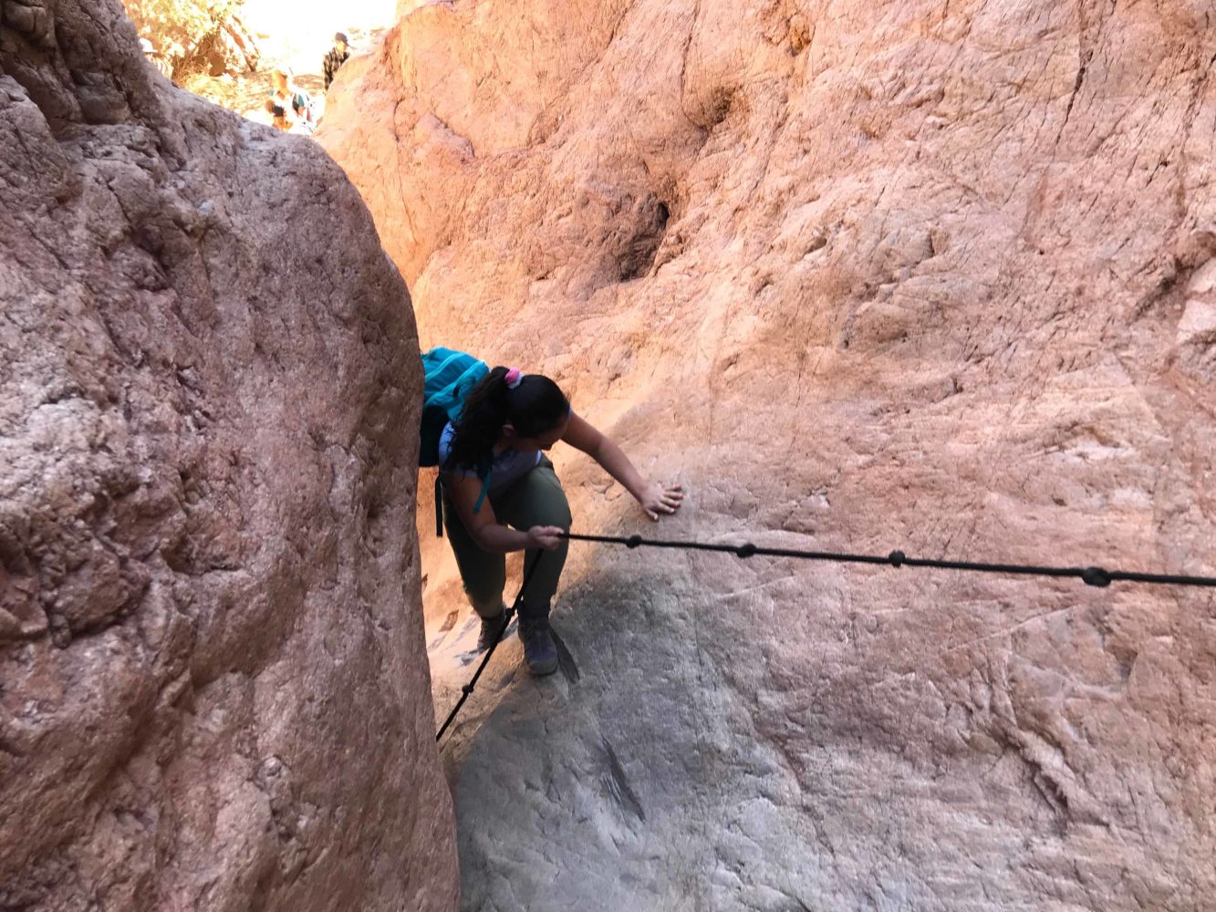 a student descending down a canyon by rope