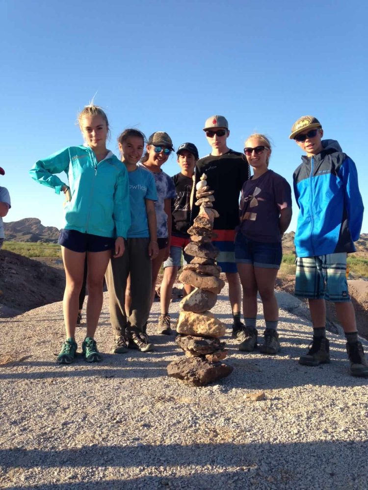 TEA students posing behind rocks stacked high